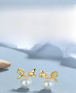Detail of 925 sterling silver bow earring with pearl and square cubic zirconia gem