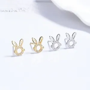 Détail de boucles d'oreilles lapin en argent et or avec zircons pavés sur carte