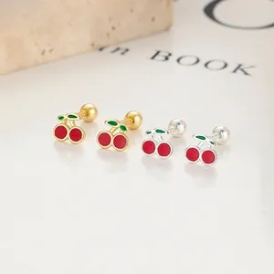 Détails macro des boucles d'oreilles cerises avec émail rouge et fermoir à vis rond