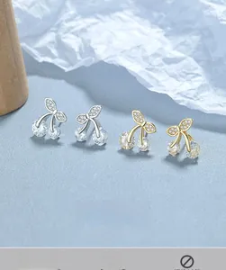 Gros plan de boucles d'oreilles cerises en argent 925 avec zircons clairs en or et en argent