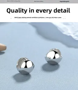 Vue macro des boucles d'oreilles boules en argent 925 avec finition miroir polie