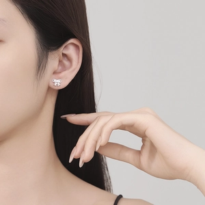 Boucles d'oreilles nœud en argent 925 avec petits zircons portées par un mannequin