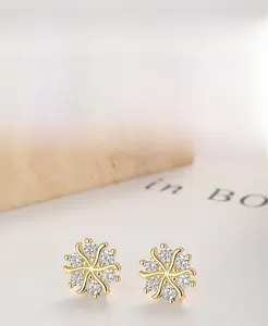 Macro detail of S925 sterling silver flower earrings with zircon insets and gold plating