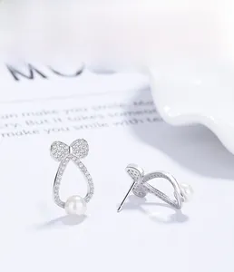 Close-up of S925 sterling silver bow earrings with micro-set zircons and round white pearls