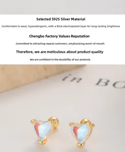 Macro detail of S925 silver heart stud earrings with iridescent moonstone and gold plating