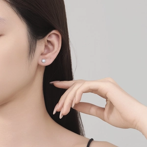 Close-up of a 925 sterling silver moonstone stud earring with twisted rope edge on ear