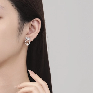925 silver bow stud earrings with white pearl drop for women on model ear