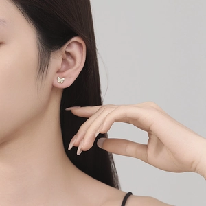 Elegante Schmetterlings-Ohrstecker aus Gold-Silber mit Zirkonia an einem Model