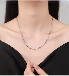 Close-up of 925 sterling silver snake chain with modern carabiner clasp on collarbone