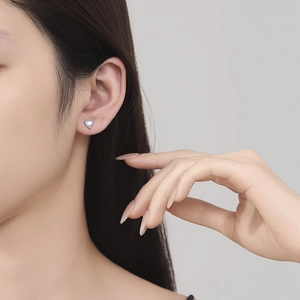 925 sterling silver heart moonstone stud earring shown on model in a minimalist style
