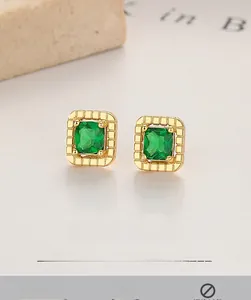 Macro shot of 925 silver square emerald studs with vintage gold textured frames