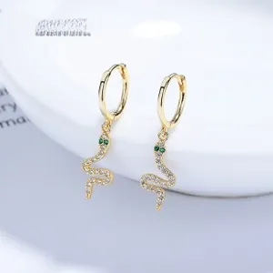 Close-up of snake earrings with white zircons and green stone eyes on white tray