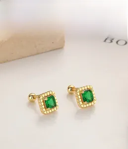 Macro detail of 925 silver emerald square stud earrings with screw ball back and gold finish