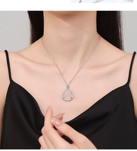 Dettaglio della collana Buddha in calcedonio rosa con pavé di zirconi su una modella