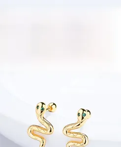 Detailed macro view of S925 sterling silver snake earrings with green gemstone eyes