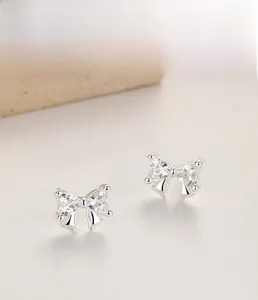 Detail of 925 sterling silver bow earrings with heart-cut cubic zirconia micro-pave