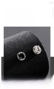 Détail macro de clous d'oreilles magnétiques en acier titane avec zircons noirs et clairs