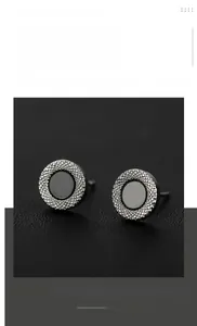 Detail of silver titanium steel earrings with black inlay and textured outer ring