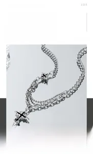Detail of layered titanium steel cross necklace with mixed chunky and bead chain style