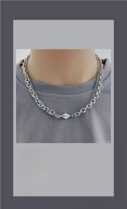 Détail du collier à double chaîne argentée avec pendentif en émail bleu et blanc