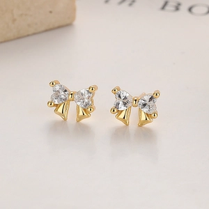 Elegant 925 sterling silver bow knot stud earrings with golden heart-shaped crystals