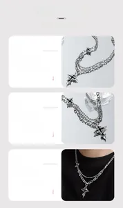 Detail of layered cross pendant necklace with silver chains worn on neck with ice props