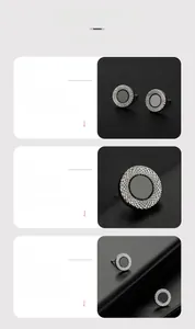 Macro shot of silver stud earrings featuring textured edges and dark grey minimalist disc