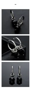 Detail view of rhombic black stone pendant earrings with silver-tone metal finish