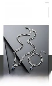 Detail of titanium steel jewelry set with dark blue gemstone pendant and lucky tag