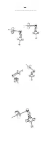 Detail view of silver cross earrings with heart charm and delicate chain links