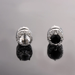 Clips d'oreilles magnétiques en zircon avec halos noir et blanc sur surface réfléchissante