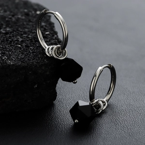 Unisex silver hoops with black rhombic zircon pendants on minimalist dark rock background
