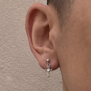 Retro silver heart cross pendant earring in punk style shown on a model's ear