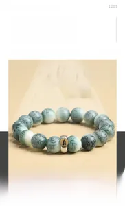Macro detail of natural Bodhi seed bracelet with green marble texture and silver mantra bead