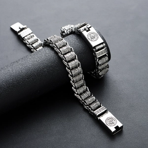 Vintage steel bracelet with engraved mantras on a black textured display stand