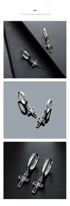 Macro detail of silver cross earrings with black enamel inlay on leather background