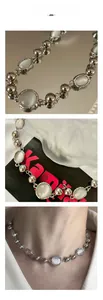 Detail view of silver bead necklace featuring oval cat's eye stones on a model's neck