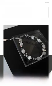Detailed view of the beaded bracelet featuring white stones and silver metal spacers