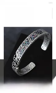 Gros plan du bracelet en acier argenté avec gravure Peace Love et incrustation d'opale
