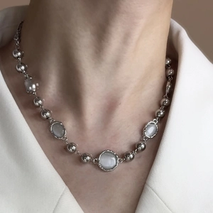 Minimalist moonstone beaded necklace with silver spheres on neck showing elegant style