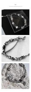 Detail of unisex bracelet with white opal beads and silver spacers on black background