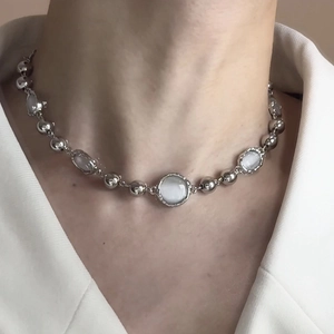 Elegant cat eye stone necklace with silver beads on a female model's neck