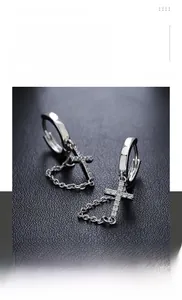 Detailed view of silver cross earring featuring sparkling rhinestones and chain fringe