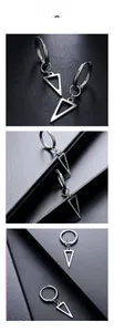 Detailed view of silver triangle drop earrings on a black textured leather surface