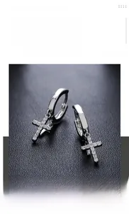 Detailed view of silver titanium steel double cross earrings with white rhinestones