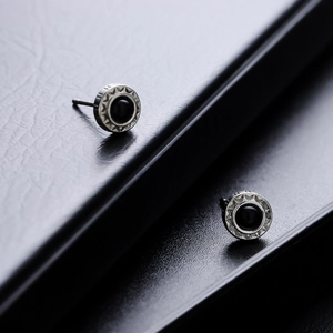 Boucles d'oreilles tournesol punk vintage avec pierre noire sur texture cuir noir