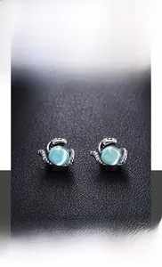 Détail macro du clip d'oreille griffe de dragon rétro avec sphère d'opale bleu clair