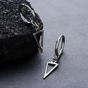Polished silver triangle hoop earrings for men and women on dark volcanic rock