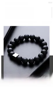 Detail of matte black lava stone beads and geometric silver square charm on the bracelet
