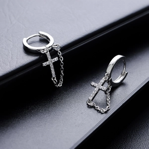 Silver-plated cross hoop earrings with cubic zirconia pavé and chains on a black background